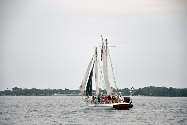 a sailboat with lots of people om board.